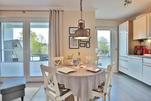 una cucina e una sala da pranzo con tavolo e sedie di Strandglück Haus C Strandglück Appartement 8C a Scharbeutz
