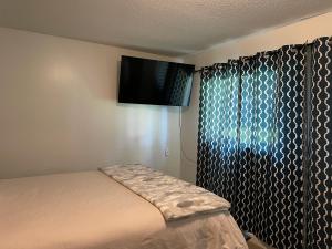 Schlafzimmer mit einem Bett und einem Flachbild-TV in der Unterkunft Bellissma Suite formerly known as Sweet Suite in Sooke