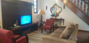 - un salon avec un canapé et une télévision dans l'établissement CASA DE PRAIA CABO FRIO, à Cabo Frio