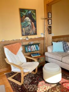 ein Wohnzimmer mit einem Stuhl und einem Sofa in der Unterkunft Blitz Beach House Oceanside Suite in Powell River