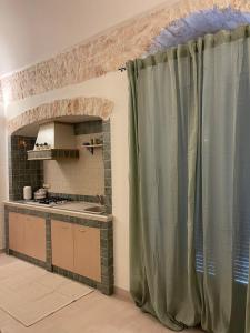een keuken met een groen gordijn in een kamer bij Casetta Nobile in Ostuni