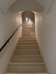 een trap in een gebouw met een stenen muur bij Casetta Nobile in Ostuni