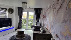 a living room with a couch and a tv at Two bed apartment with balcony Slough,Windsor,Legoland in Slough