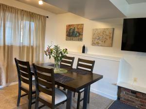 a dining room with a table and chairs and a television at Bellissma Suite formerly known as Sweet Suite in Sooke
