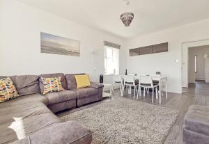a living room with a couch and a dining room at PLAS DARIEN-3 BED APT- SEA VIEWS - SLEEPS 5 in Trearddur