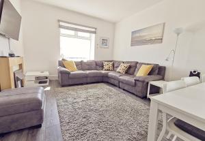a living room with a couch and a table at PLAS DARIEN-3 BED APT- SEA VIEWS - SLEEPS 5 in Trearddur