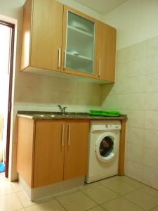 a kitchen with a washing machine and a sink at Casa da Baixa in Faro