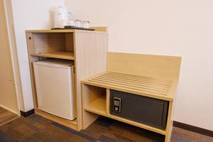 a small cabinet with a microwave in a room at Floral Hotel East Shinsaibashi in Osaka
