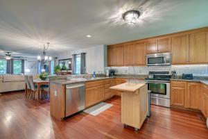 a large kitchen with wooden cabinets and a table at Homey Murrells Inlet Vacation Rental Near Marina in Myrtle Beach
