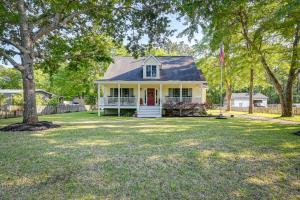 uma casa branca com uma bandeira num quintal em Homey Murrells Inlet Vacation Rental Near Marina em Myrtle Beach