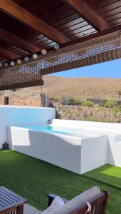 een patio met een witte bank en gras bij Casa Notas de Color Y Sal in Agaete