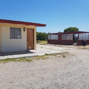 a small house with a door and a gravel driveway at APARTHOTEL Santa Maria in Punta de Choros