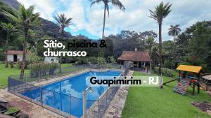 eine Villa mit einem Pool und einem Spielplatz in der Unterkunft Paradisíaco, piscina e churrasqueira em Guapi. in Guapimirim