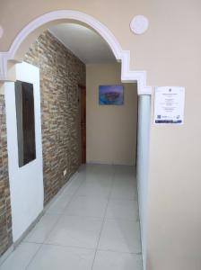 um corredor vazio com uma parede de tijolos e um arco em Alojamientos Laila Sai y Zaida em San Andrés