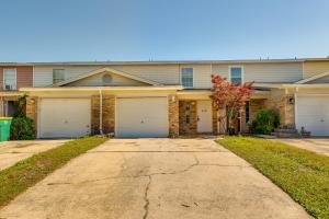 uma casa com duas portas de garagem e uma entrada em Breezy Fort Walton Townhome about 5 Mi to Beach! em Fort Walton Beach