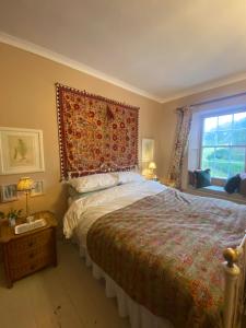 um quarto com uma cama grande e uma janela em Historic House in Beatrix Potter Village em Near Sawrey