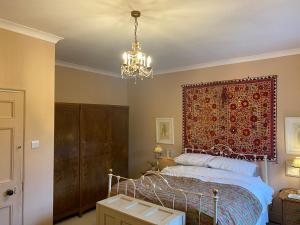 a bedroom with a bed and a chandelier at Historic House in Beatrix Potter Village in Near Sawrey