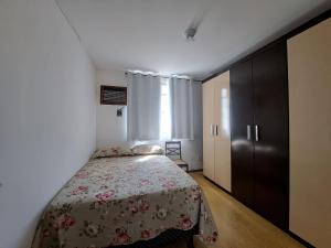 1 dormitorio con 1 cama con colcha de flores en Lindo Apto com VAGA no melhor da Ilha do Gov, en Río de Janeiro