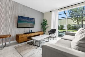 a living room with a couch and a flat screen tv at 4 Bedrooms 35 Bathrooms Le Reve 4423 Lr in Kissimmee