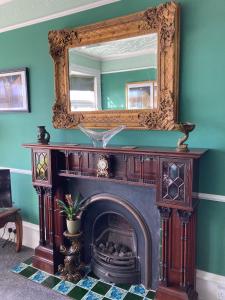 a fireplace with a mirror above it in a room at Paragon Home in Ramsgate