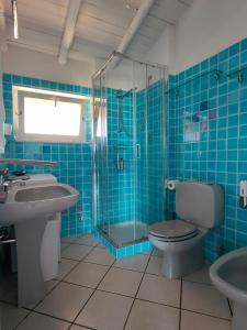 a bathroom with a toilet and a sink and a shower at Villa Unica - Appartamenti Alba e Tramonto in Isola Rossa