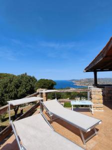 a hammock on a patio with a view of the ocean at Villa Unica - Appartamenti Alba e Tramonto in Isola Rossa