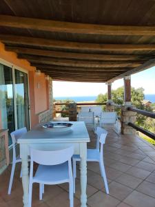 una mesa blanca y sillas en un patio en Villa Unica - Appartamenti Alba e Tramonto, en Isola Rossa