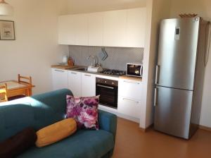 eine Küche mit einem blauen Sofa und einem Kühlschrank in der Unterkunft Appartamento La Betulla in San Giovanni in Marignano