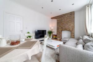 a living room with a couch and a table at 2 Bedroom Duplex Apartment in London