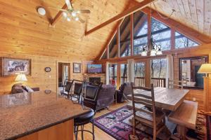 a dining room and living room in a log cabin at Above the Clouds, 4 Bedrooms, Pool Access, Private, Gaming, Sleeps 16 in Gatlinburg
