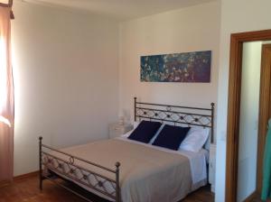 ein Schlafzimmer mit einem Bett mit blauen Kissen in der Unterkunft Appartamento La Betulla in San Giovanni in Marignano