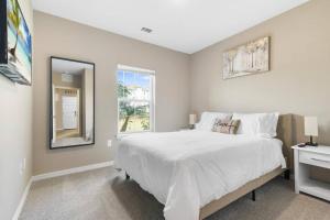 a white bedroom with a large bed and a window at Luxury 3 Bedroom/2 Bathroom Condo in Melbourne FL with Pool, Gym and Laundry in Melbourne +42 photos
