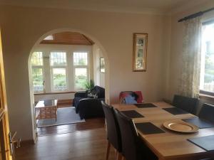 a dining room and living room with a table and chairs at Rowan Cottage Highland retreat near Fort William in Spean Bridge