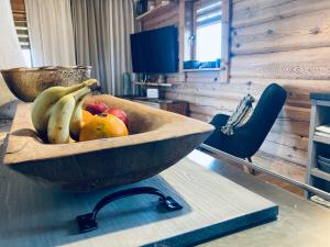 un bol de fruta de madera sobre una mesa en Dižbraki en Ventspils