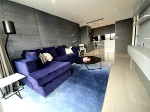 ein Wohnzimmer mit einem lila Sofa und einem Tisch in der Unterkunft Club White London Bridge One Bedroom Apartment in London