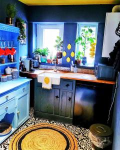 a blue kitchen with a sink and a window at charming full of character in the heart Southwell in Southwell