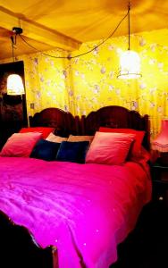a bedroom with a large bed with pink sheets at charming full of character in the heart Southwell in Southwell