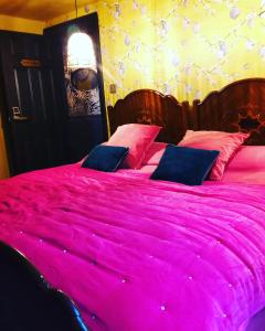 a large pink bed with pink pillows on it at charming full of character in the heart Southwell in Southwell