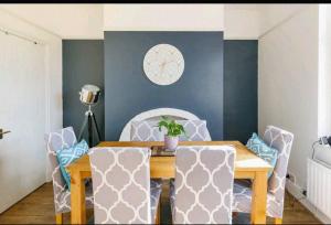 a dining room with a wooden table and chairs at Atrium House in Hazel Grove