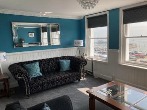 a living room with a couch and a mirror at Paragon Home in Ramsgate
