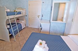 a small room with bunk beds and a little girl at Hotel Capital in Cupra Marittima