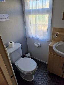 uma casa de banho com um WC, um lavatório e uma janela em Just Resort No29 em Balminnoch