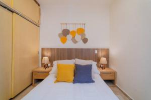 a bedroom with a bed with yellow and blue pillows at Casa nueva a 3 min del Malecón! in La Paz