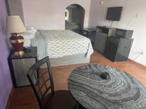 a room with two beds and a table with a lamp at The village inn in Denham Springs