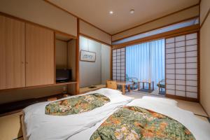 Postel nebo postele na pokoji v ubytování Ryokan Ryokufuso