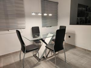 uma mesa de vidro com cadeiras pretas num quarto em villa bonita em Corralejo