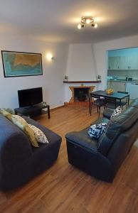 uma sala de estar com um sofá e uma mesa em Casa Zeferino em Ferragudo