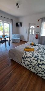 1 dormitorio con 1 cama grande y 1 mesa en Casa Zeferino, en Ferragudo