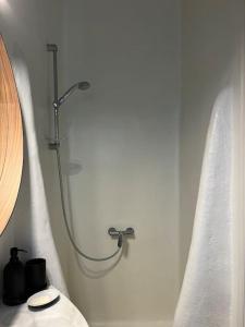 y baño con ducha y cortinas blancas. en Villa Cybele Tinos, en Kardhianí