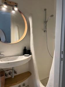 bagno con lavandino e doccia con specchio di Villa Cybele Tinos a Kardhianí